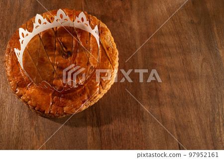 King cake or galette des rois in French. Epiphany pie with golden paper crown King cake or galette des rois in French. Epiphany pie with golden paper crown 97952161
