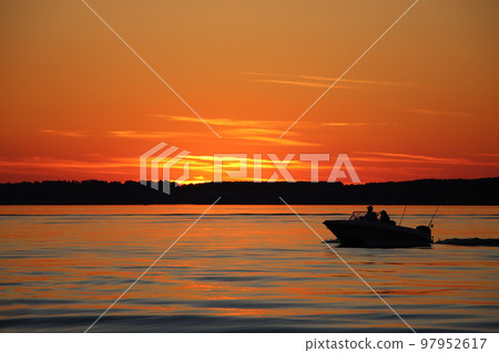 Silhouette of two fisherman on the boat. Beautiful sunset on the background. Silhouette of two fisherman on the boat. Beautiful sunset on the background. 97952617