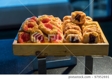 Assortment of fresh pastry on table in buffet. 97952691