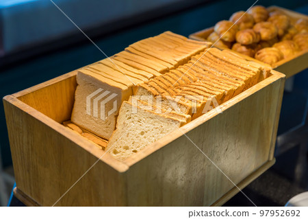 Assortment of fresh bread on table in buffet. Sliced white bread 97952692