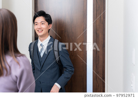 Husband going to work and wife seeing off at the entrance (couple / couple) Husband going to work and wife seeing off at the entrance (couple / couple) 97952971