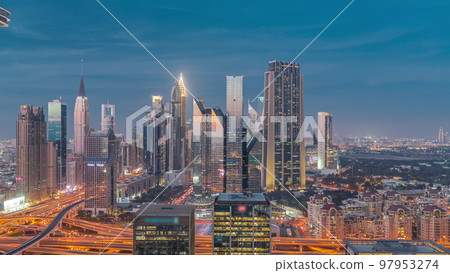 Panorama of Dubai Financial Center district with tall skyscrapers with illumination day to night timelapse. 97953274