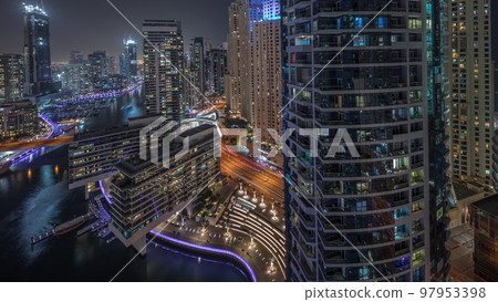 Aerial view to Dubai marina skyscrapers around canal with floating boats night timelapse Aerial view to Dubai marina skyscrapers around canal with floating boats night timelapse 97953398
