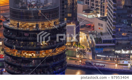 Dubai marina waterfront and building with different restaurants at each floor aerial night to day timelapse. 97953404