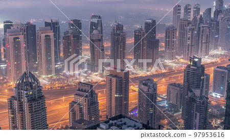 JLT skyscrapers and marina towers near Sheikh Zayed Road aerial night to day timelapse. Residential buildings 97953616