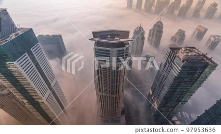Rare early morning winter fog above the Dubai Marina skyline and skyscrapers rooftops aerial timelapse. Rare early morning winter fog above the Dubai Marina skyline and skyscrapers rooftops aerial timelapse. 97953636