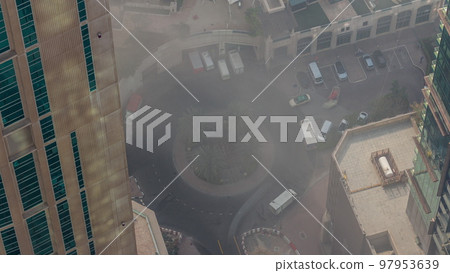 Aerial view of a road intersection between skyscrapers in a big city timelapse. Aerial view of a road intersection between skyscrapers in a big city timelapse. 97953639