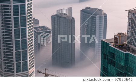 Rare early morning winter fog above the Dubai Marina skyline and skyscrapers rooftops aerial timelapse. Rare early morning winter fog above the Dubai Marina skyline and skyscrapers rooftops aerial timelapse. 97953645