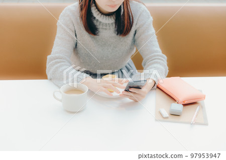 Photo of a young college girl listening to music in a cafe Photo of a young college girl listening to music in a cafe 97953947