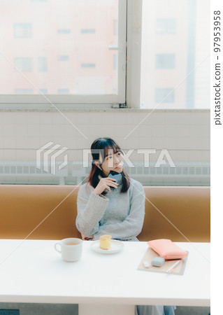 Photo of a young college girl listening to music in a cafe Photo of a young college girl listening to music in a cafe 97953958