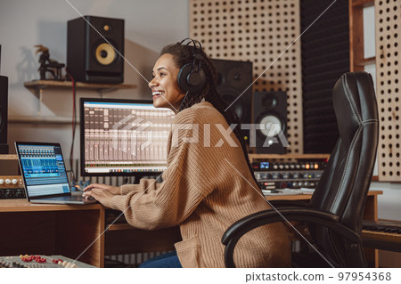 Charming multiracial anchor woman, presenter, sound engineer, producer recording podcast in professional music studio Charming multiracial anchor woman, presenter, sound engineer, producer recording podcast in professional music studio 97954368