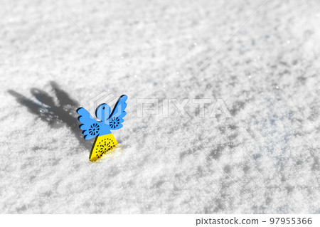 blue and yellow toy angel on white snow blue and yellow toy angel on white snow 97955366