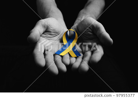 man hands hold yellow blue ribbon 97955377