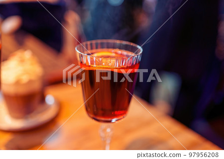 Christmas mulled wine or gluhwein with spices with hot steam, traditional drink on winter holiday, selective focus 97956208