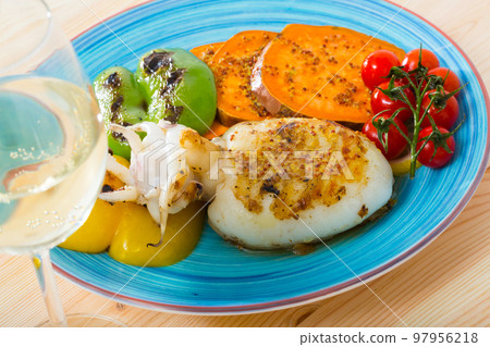 Sepia fried on a grill with Bulgarian pepper and boiled batat is tasty dish 97956218