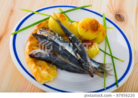 Dish of tasty fried anchovy with potato croquettes and cake served Dish of tasty fried anchovy with potato croquettes and cake served 97956220