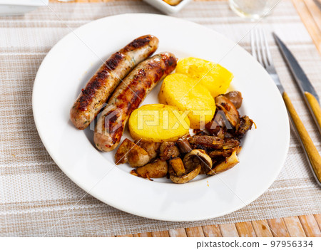 Appetizing dish made from sausages with potatoes and mushrooms Appetizing dish made from sausages with potatoes and mushrooms 97956334