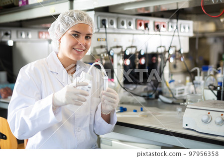 Efficient female lab technician working with reagents in test tubes during chemical experiment Efficient female lab technician working with reagents in test tubes during chemical experiment 97956358