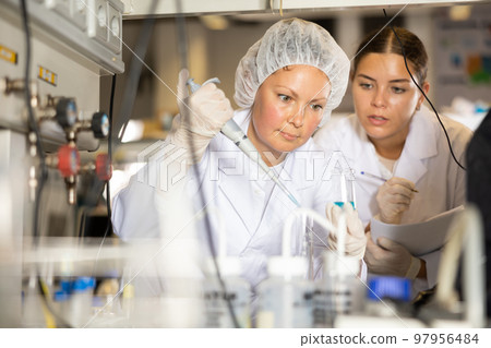 Confident women technicians working in research laboratory 97956484