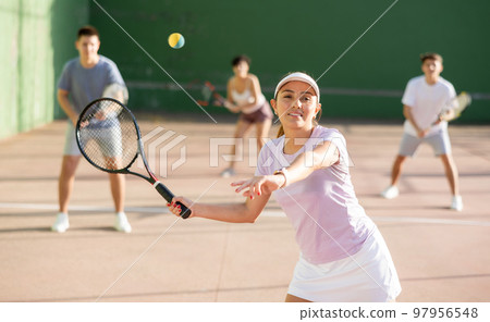 Expressive resolved fit girl playing frontenis ball friendly match on court 97956548