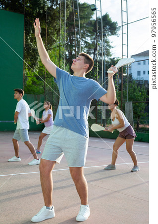 Young man playing Basque pelota on outdoor pelota court 97956565