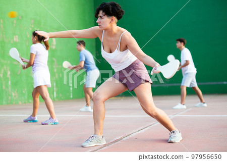 Woman serving ball during frontenis game outdoors 97956650