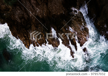 Amazing top view beautiful seashore, Aerial view crashing waves on rocks, Dark sea surface seashore rocks cliffs background Amazing top view beautiful seashore, Aerial view crashing waves on rocks, Dark sea surface seashore rocks cliffs background 97957032