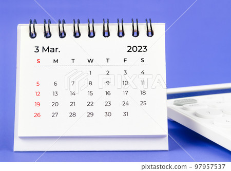 The March 2023 Monthly desk calendar for 2023 year with calculator on purple background. 97957537