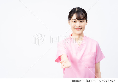 Young female nurse wearing a pink scrub reaching out Young female nurse wearing a pink scrub reaching out 97958752