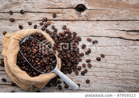 Background of dark roasted coffee beans with scoops setup on wooden background with copy space. Background of dark roasted coffee beans with scoops setup on wooden background with copy space. 97959313