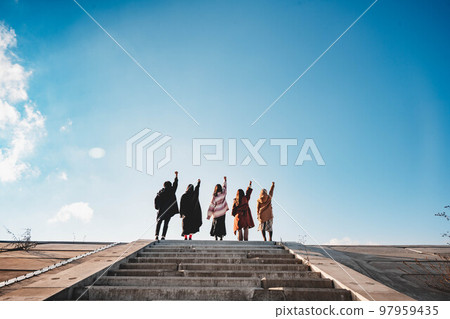 五個朋友在藍天下愉快地跑上樓梯 97959435