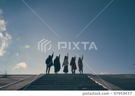五個朋友在藍天下愉快地跑上樓梯 五個朋友在藍天下愉快地跑上樓梯 97959437