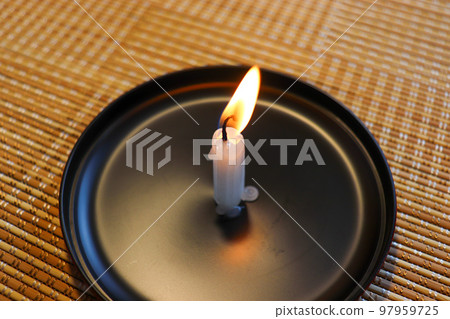 A candle that is lit and melting A candle that is lit and melting 97959725