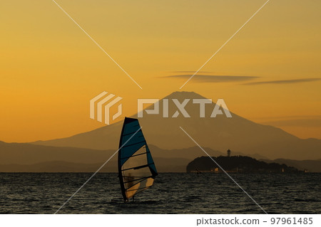 A young man who enjoys windsurfing in the orange sky and sea at dusk on the Zushi coast in winter 97961485