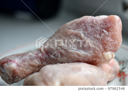 Frozen chicken thighs on a plate. Frozen chicken thighs on a plate. 97962546