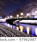 Illuminated river and snow-covered bridge 97962987