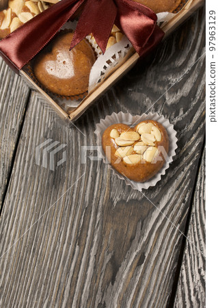 Homemade caramel. Brown caramel candies. Creamy sweets with peanuts. On pine boards. Some of them are packed in a box and tied with a ribbon. Homemade caramel. Brown caramel candies. Creamy sweets with peanuts. On pine boards. Some of them are packed in a box and tied with a ribbon. 97963129