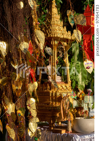 Thai Buddha altar, offerings, lanterns, golden leaves of Bodhi tree.  97964783