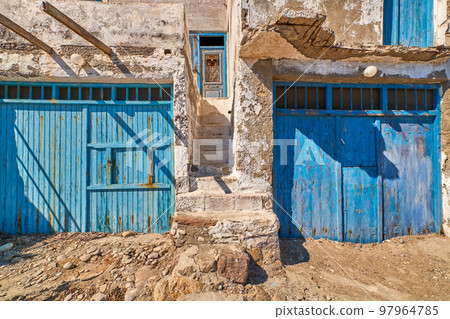 Faded and weathered white wall and stairs, blue painted door, Greece. Traditional architecture, details, authentic facade, sunny day, sunshine, shadow 97964785