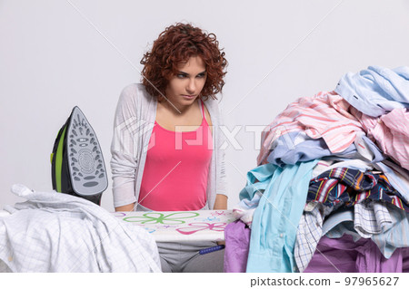 A girl terribly angry that she has to iron men's shirts again. 97965627
