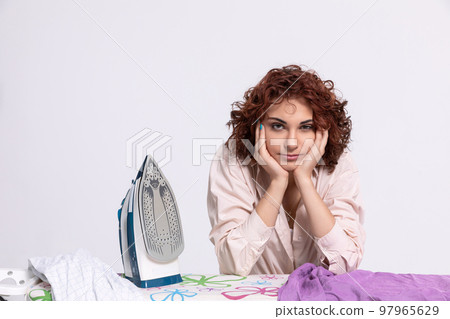 Boring household chores. Pause while ironing men's shirts. 97965629