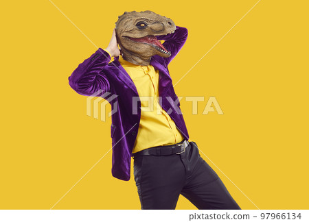 Cool party man in trendy dinosaur mask doing dance moves having fun at themed party. 97966134