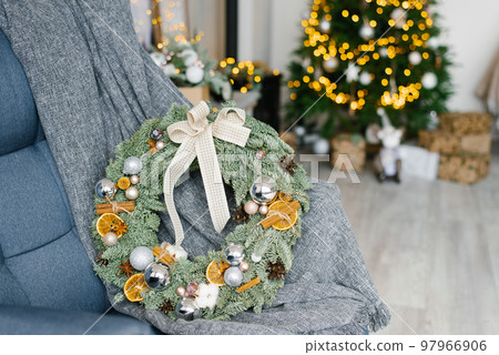 Stylish trending Christmas wreath with Christmas balls, dried orange slices and cinnamon in room decor Stylish trending Christmas wreath with Christmas balls, dried orange slices and cinnamon in room decor 97966906