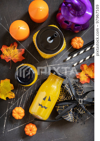 Pumpkin drink on a festive halloween table and Halloween pumpkins, lantern and decoration on dark stone background. Top view flat lay background. 97967589