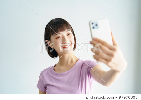 一個穿著運動服拿著智能手機的女人 97970305