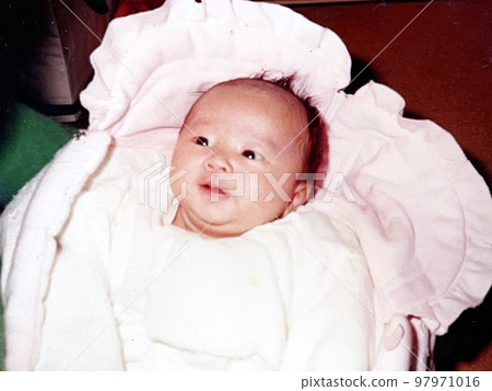 Japan in the 1970s, a baby smiling in a swaddle Japan in the 1970s, a baby smiling in a swaddle 97971016