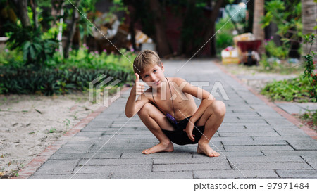 Boy blond freckles squatting sit smiling show gesture thumbs up shirtless bare chested shorts nature 97971484