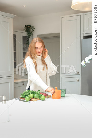 Young woman is preparing in the kitchen. Healthy Food. Salad. Diet. Dieting Concept. Healthy Lifestyle. Cooking At Home. Prepare Food. Cutting ingredients on the table 97973085