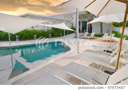 Philippines resort hotel poolside, umbrellas and deck chairs 97973487