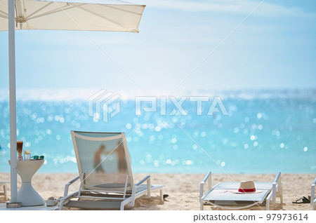 Umbrellas and deck chairs on the white sandy beach of an Asian luxury resort hotel 97973614